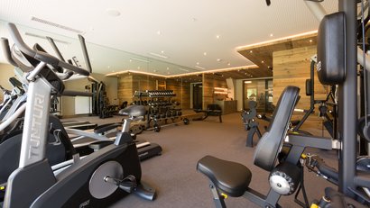 Palestra moderna con attrezzature per il fitness e pesi davanti a pareti in legno