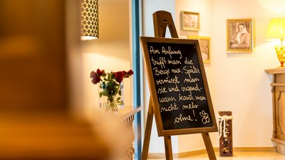 Schwarzes Kreidetafel mit deutscher Schrift in gemütlichem, warm beleuchtetem Raum