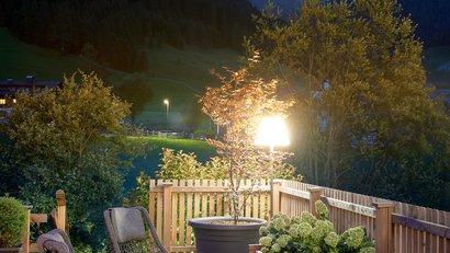 Terrazza accogliente con sedie e piante in paesaggio montano al crepuscolo