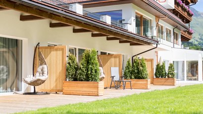 Terrasse eines modernen Gebäudes mit Holzpflanzkästen und Sitzmöglichkeiten